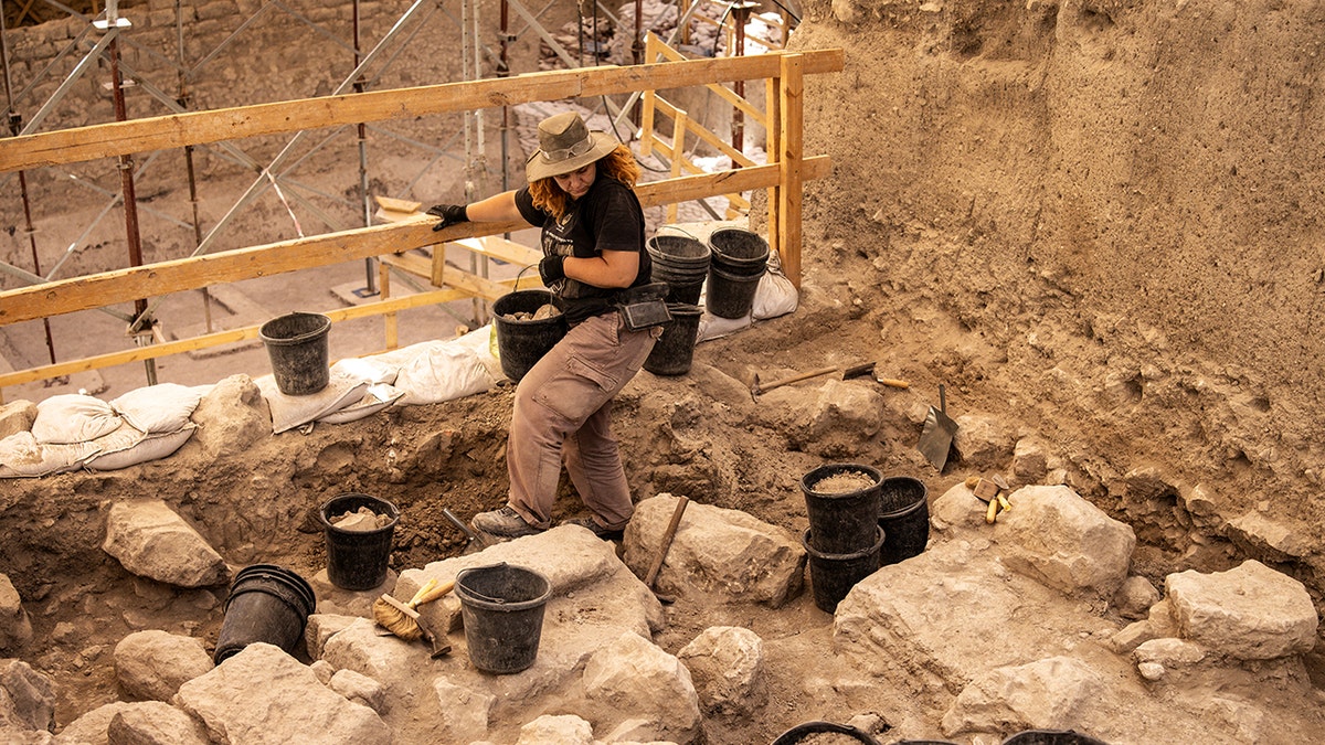Archaeologist walking among stones at site