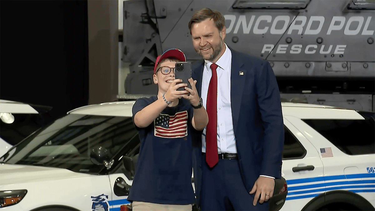 Vice President JD Vance poses for a selfie with a young supporter wearing a Trump hat at a speech in Concord, North Carolina