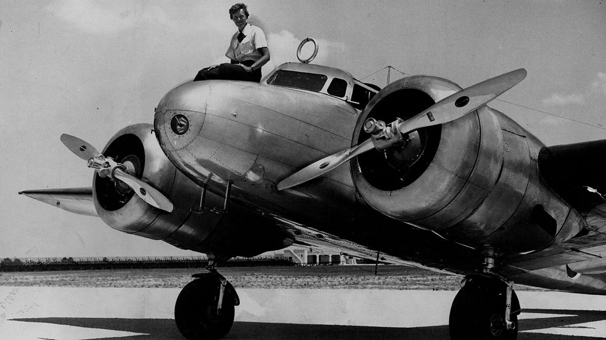 Amelia Earhart atop of an airplane. 