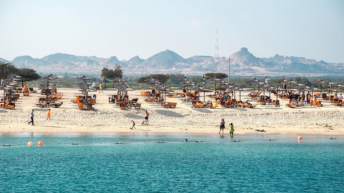 Sir Bani Island tourists near shore
