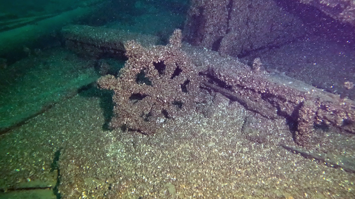 Wheel covered in ocean sediment at shipwreck site