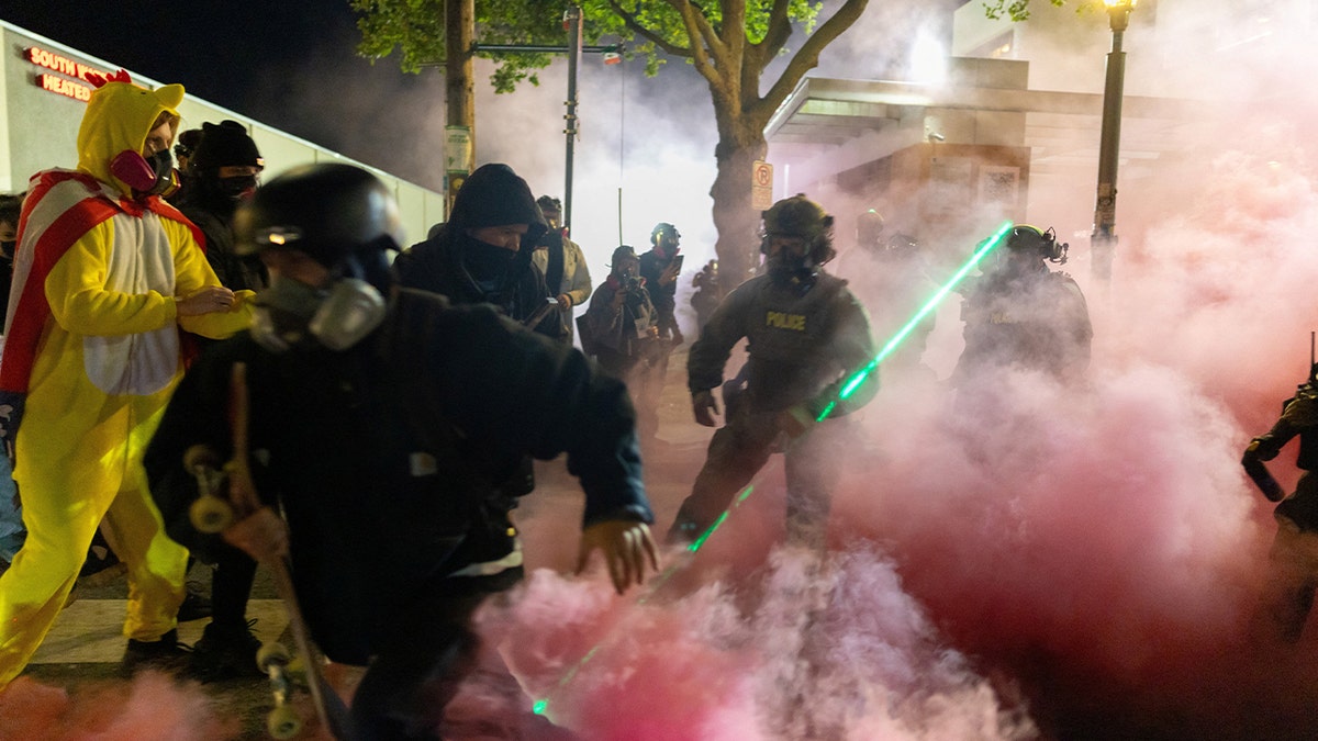 A protestor reacts as law enforcement officers deployed smoke grenades to disperse people gathered outside the U.S. Immigration and Customs Enforcement (ICE) headquarters in south Portland, Oregon, U.S., October 5, 2025.