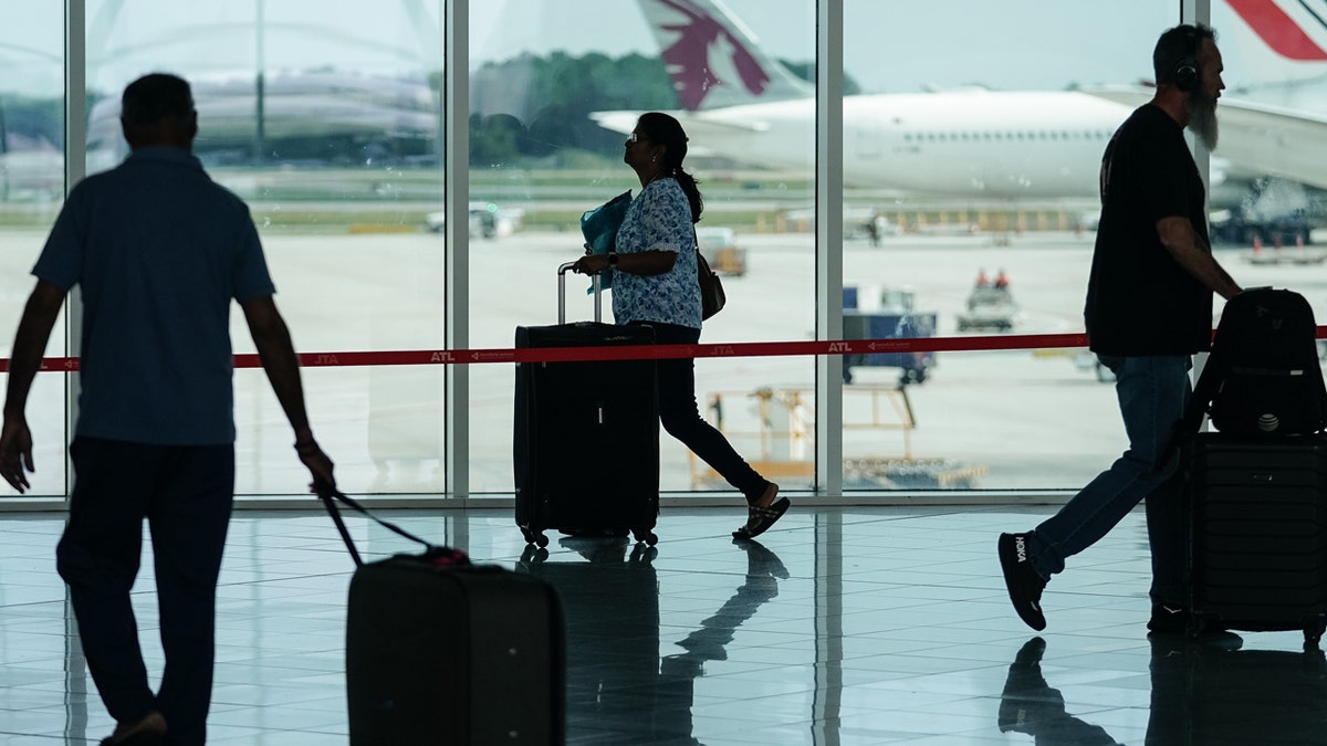 Passengers walk through Atlanta Airport