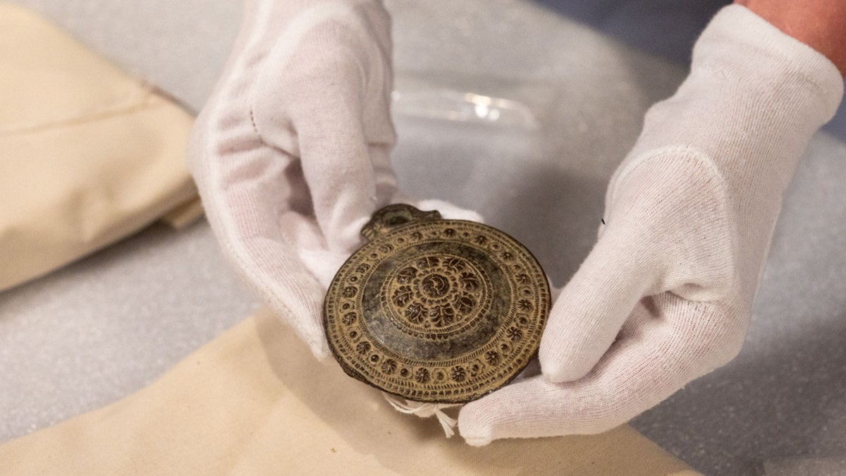 Archivist holding large ancient medallian