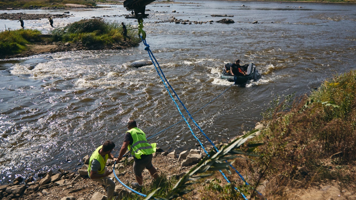 Archaeologists pulling heavy objects from Vistula