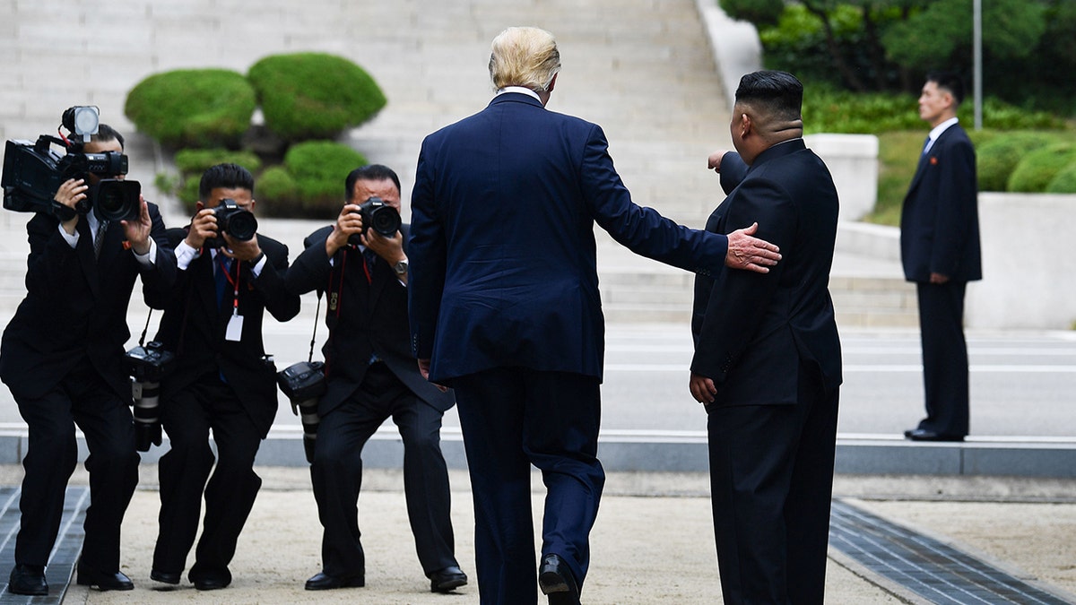 President Trump poses with Kim Jong Un before cameras