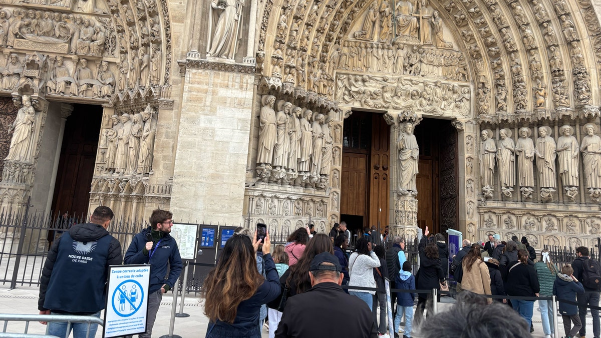 tourists in line outside of Notre Dame Cathedral