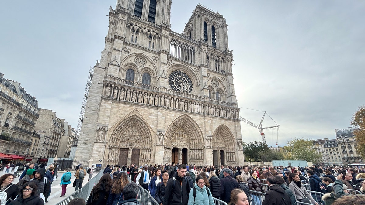 tourists in line outside of Notre Dame Cathedral