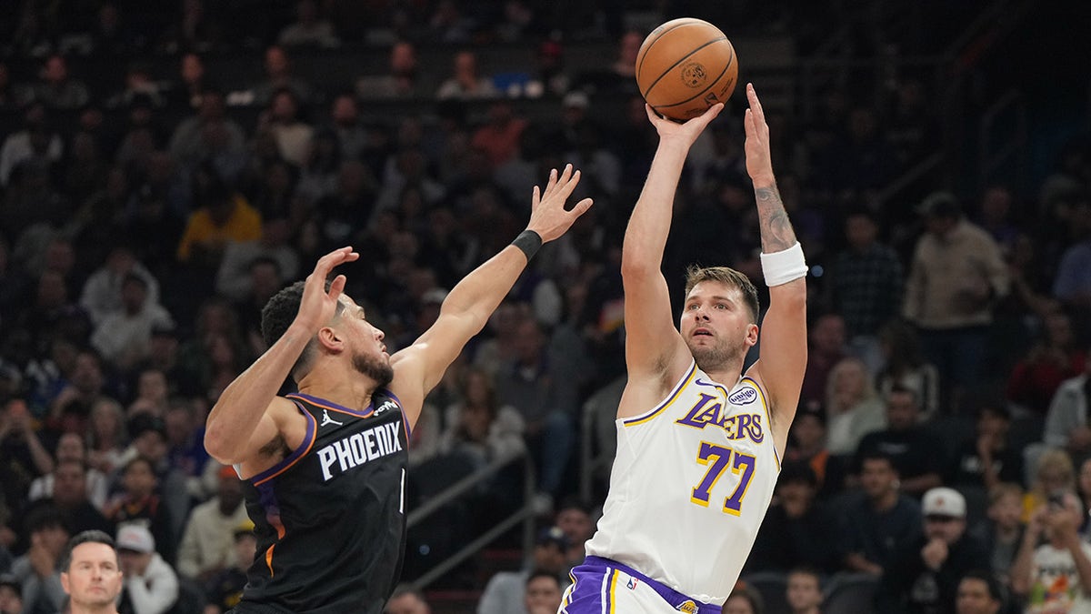 Luka Doncic shoots over Devin Booker