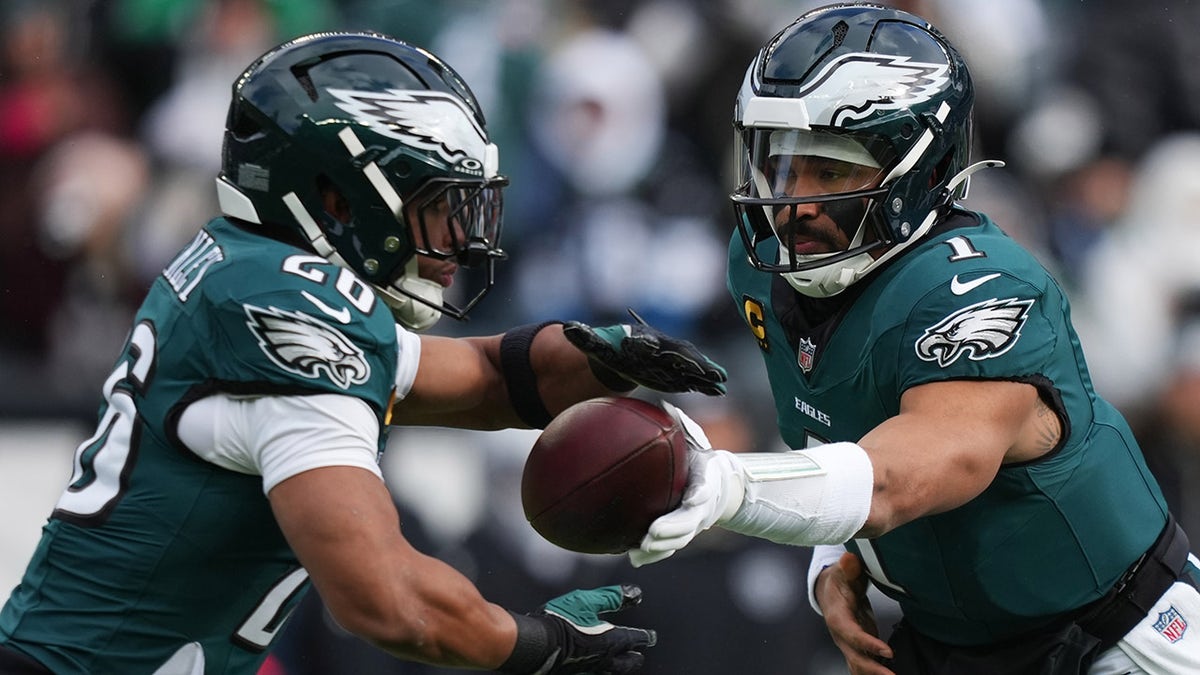 Jalen Hurts hands the ball to Saquon Barkley