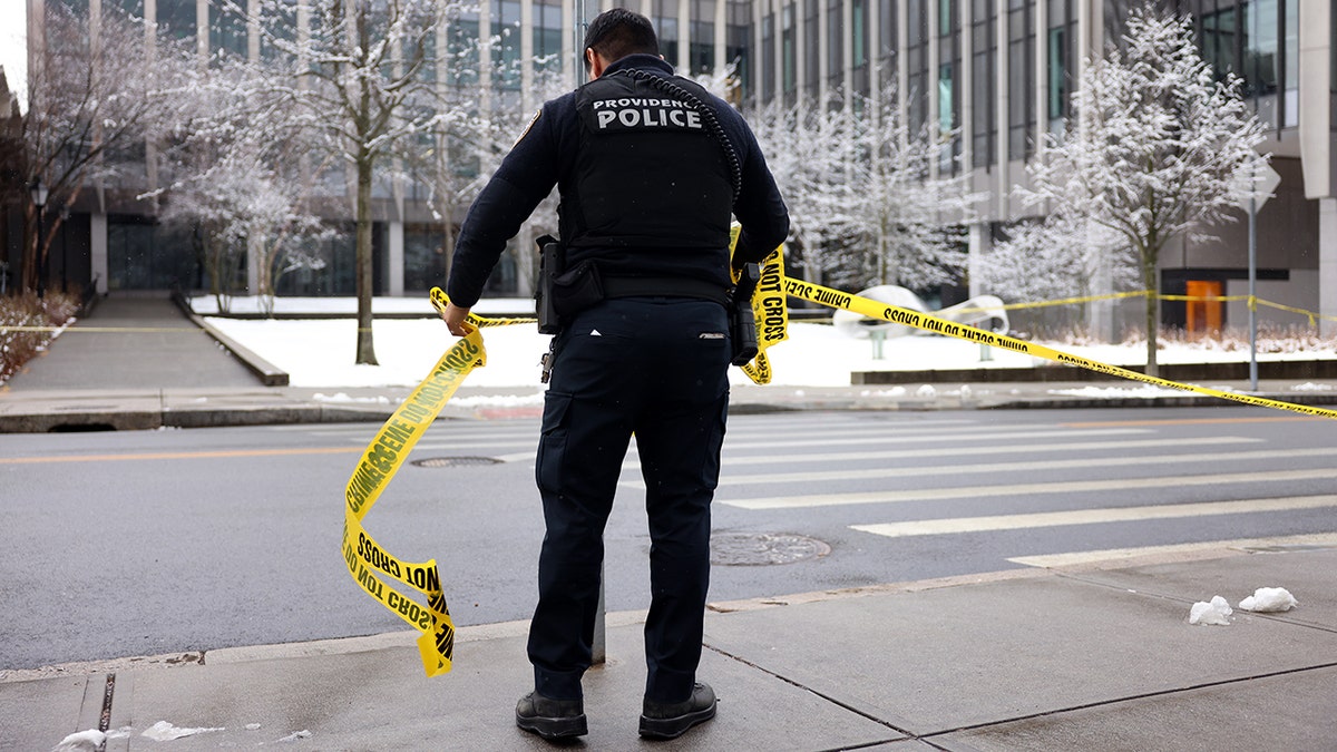Police officer takes down crime scene tape