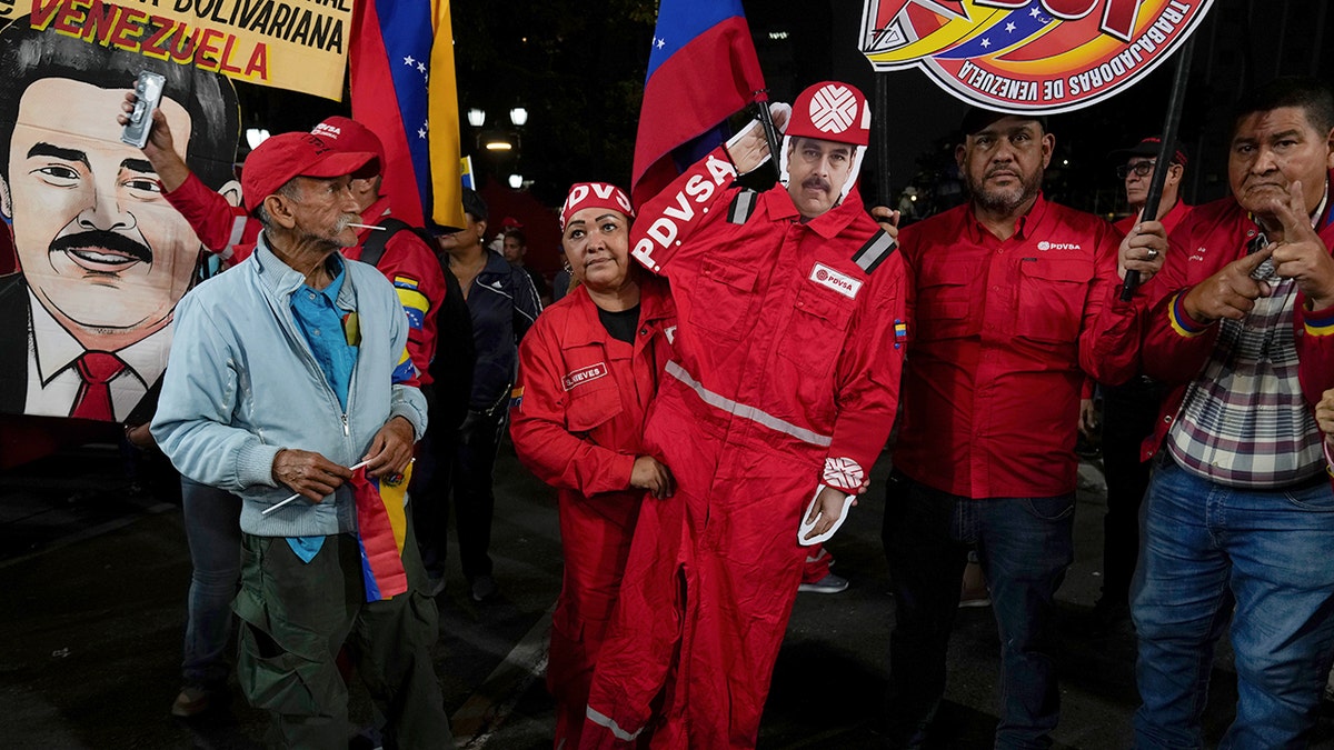 Oil worker holds cutout of Maduro dressed as PDVSA employee