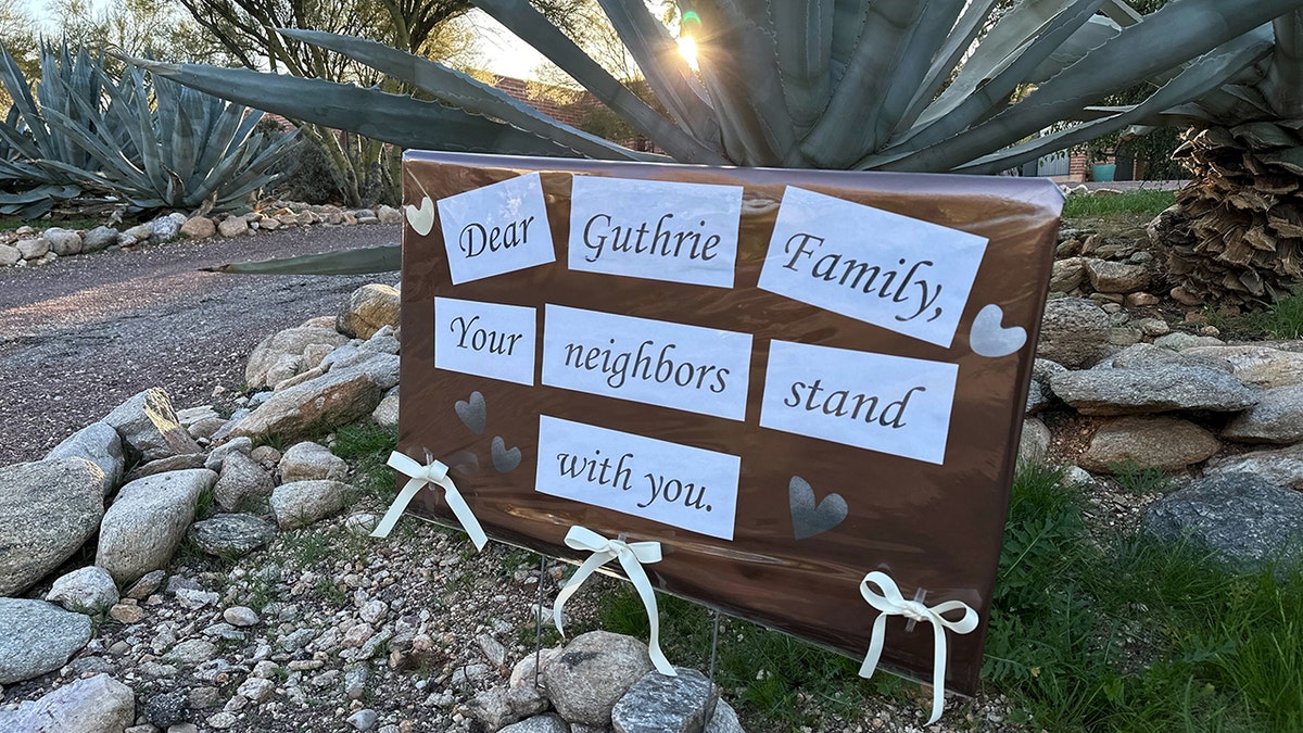 A supportive sign from neighbors posted on a fence outside Nancy Guthrie's home.