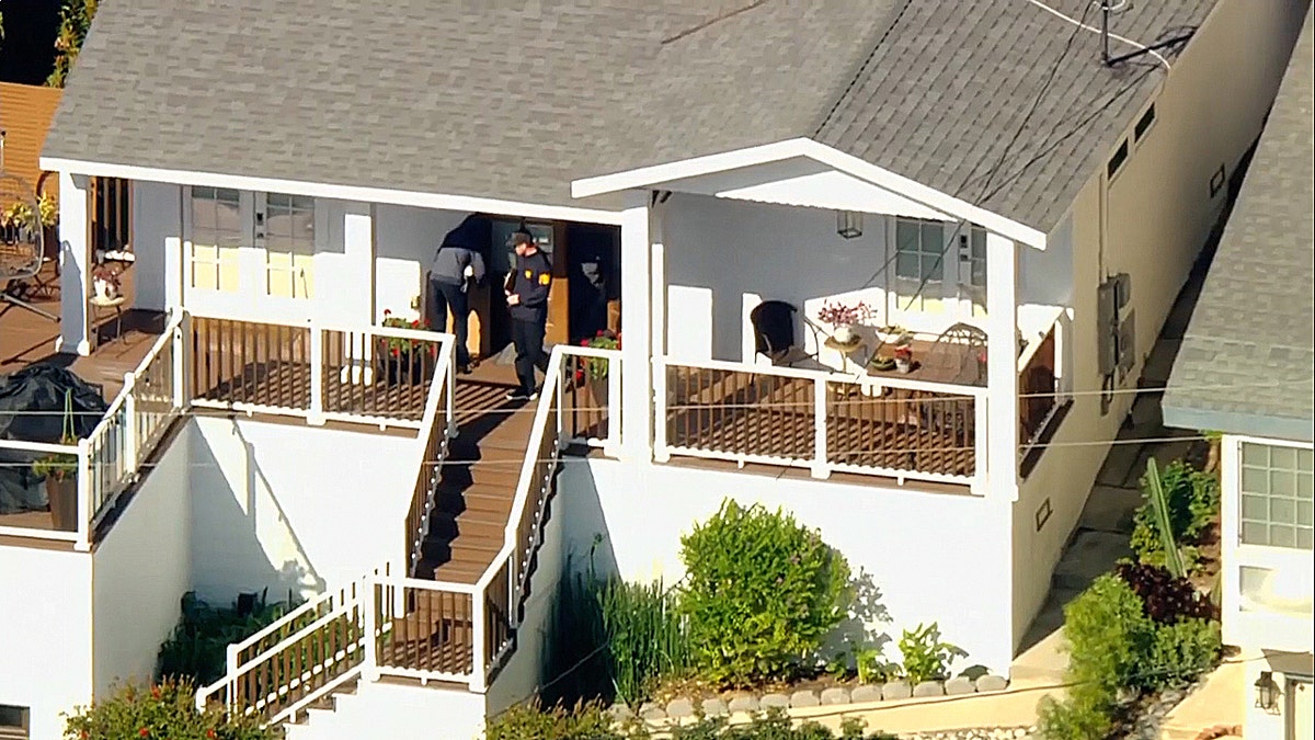 federal officials carring cardboard out of a home