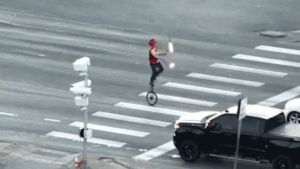 Fire-juggling unicyclist caught on camera blocking traffic in major roadway as police intervene