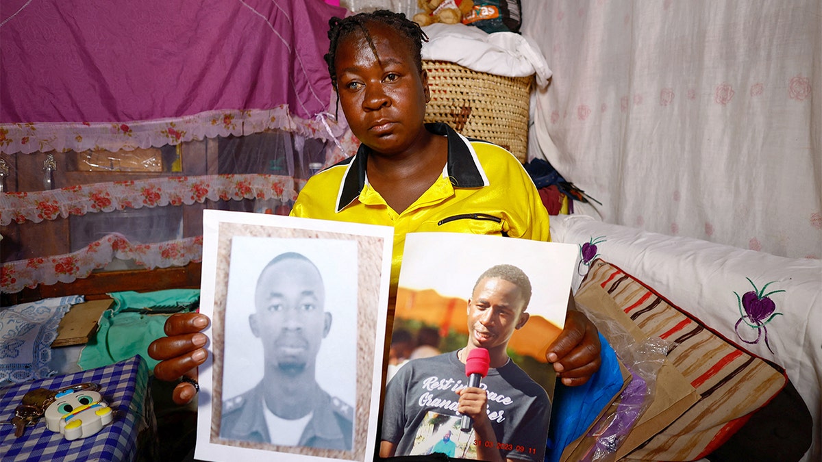 A woman holds framed photographs of a young man while inside her home in Nairobi.
