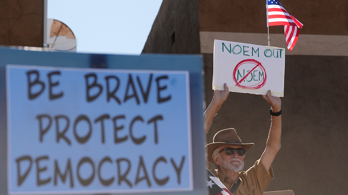 Protesters held signs during a protest against immigration enforcement operations after Kristi Noem, Secretary of the Department of Homeland Security, spoke at the border Wednesday, Feb. 4, 2026, in Nogales, Ariz.