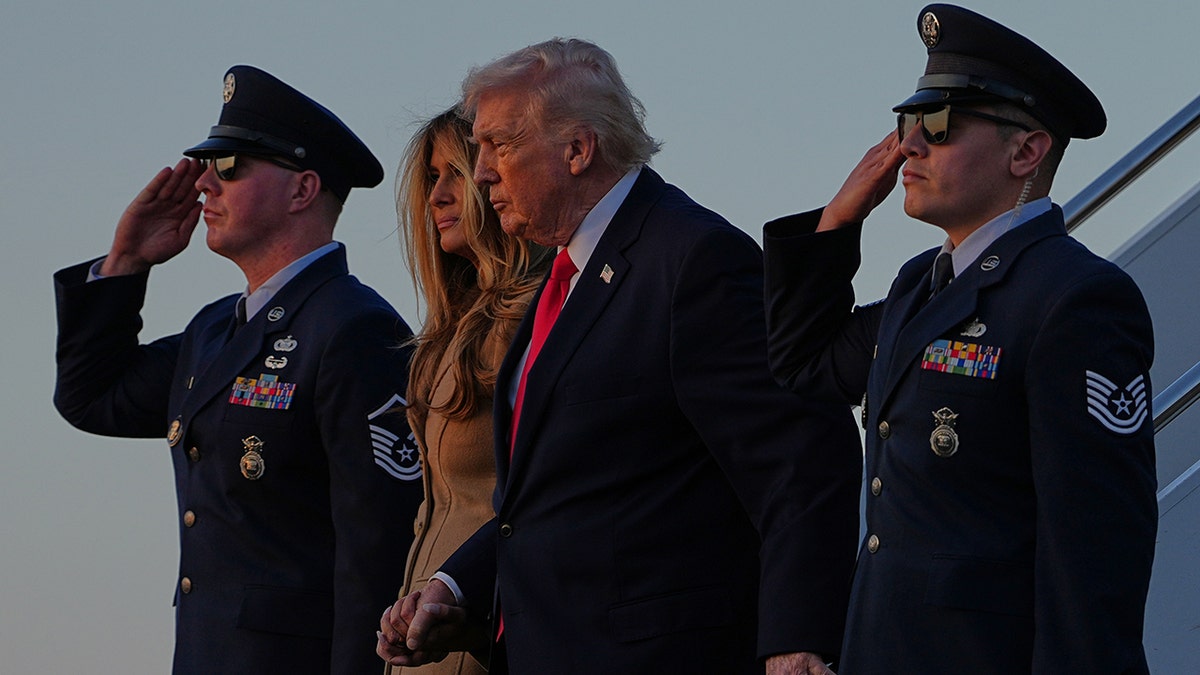 Donald Trump and Melania Trump walking down the stairs of Air Force One.