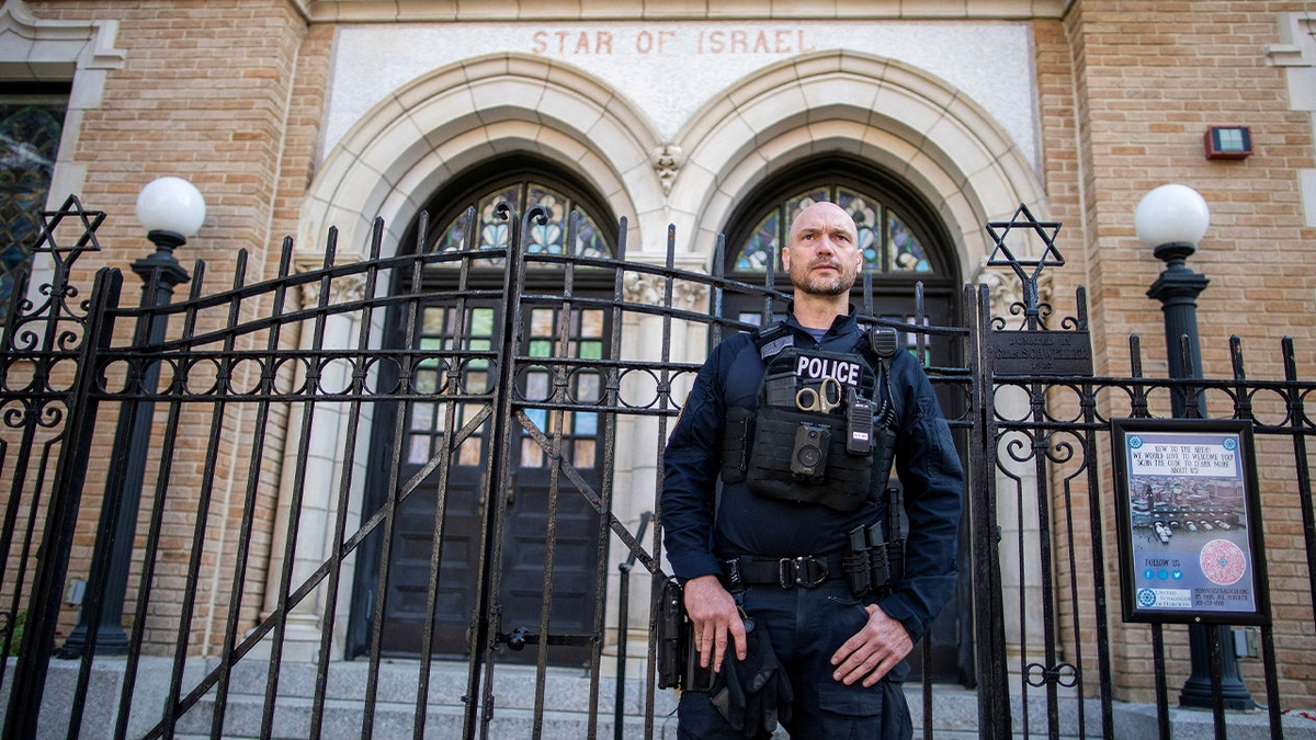 A New Jersey police officer stands guard in front of the United Synagogue of Hoboken in New Jersey, U.S.