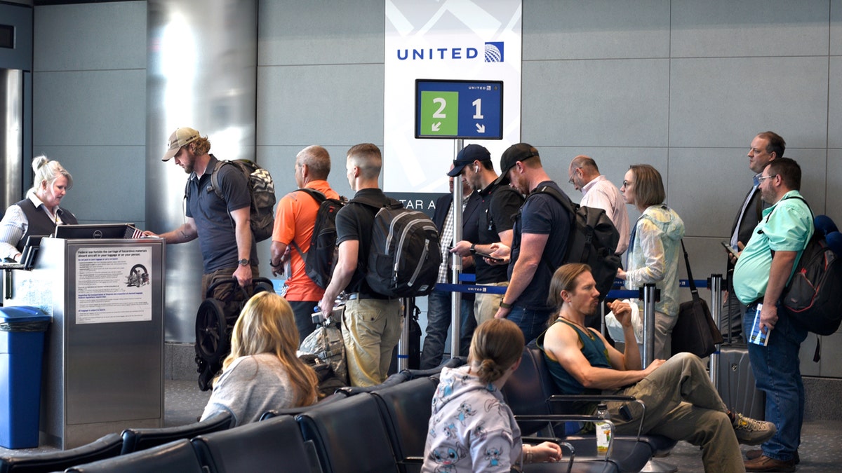 Passengers gather at United Airlines gate to board plane