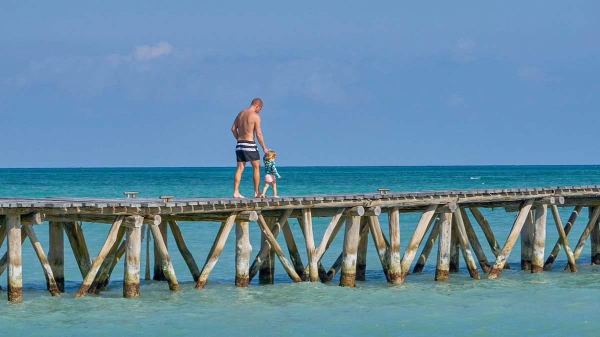 father and daughter walking on Isla Pasion beach in mexico