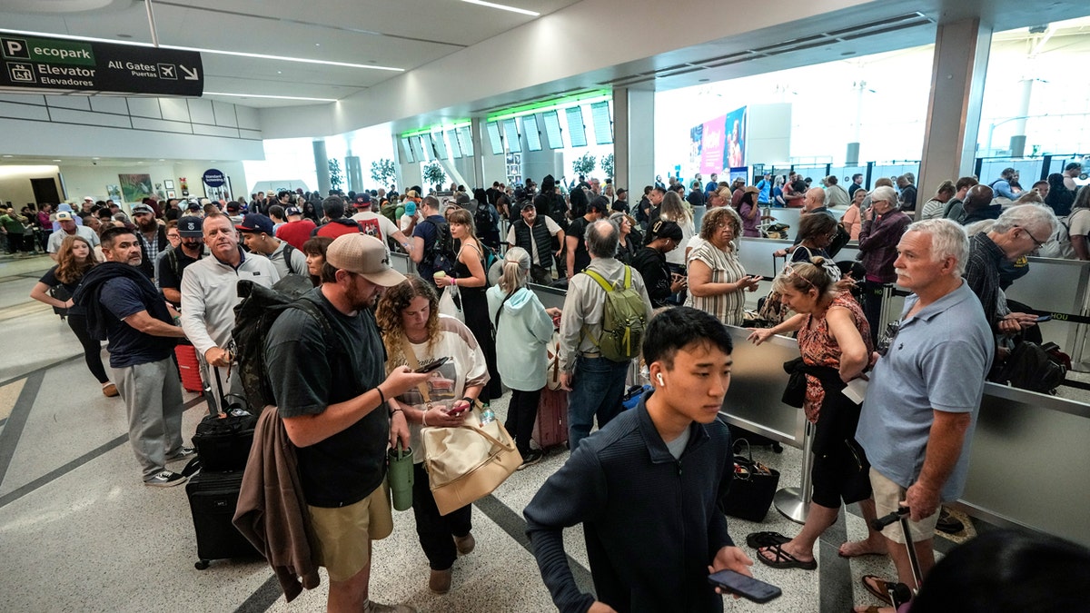 Airline passengers wait in long lines to get through the TSA security screening at William P. Hobby Airport in Houston, Sunday, March 8, 2026. The line stretched from the security checkpoint into the lower level baggage claim area to the lower level parking garage.