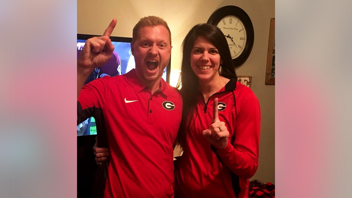 Jason and Laura Hughes smiling in an undated photo wearing University of Georgia football gear