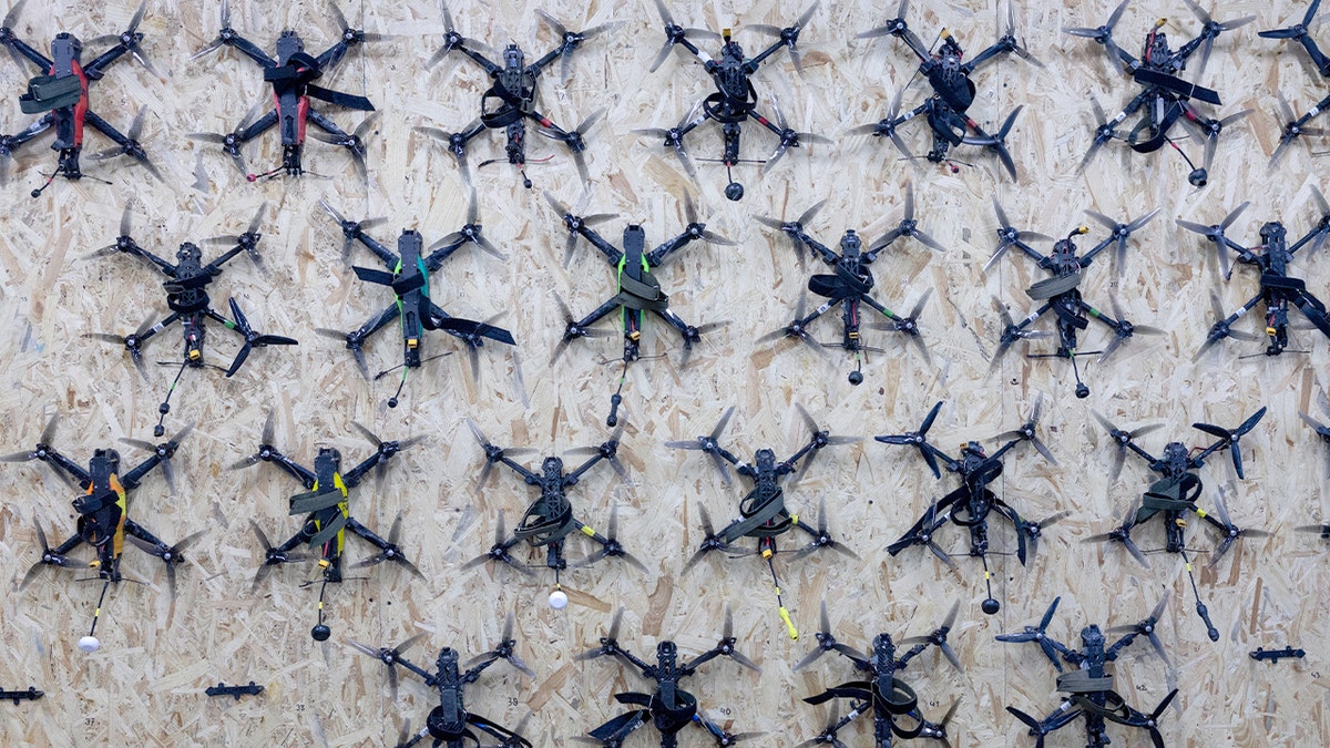 First-person-view training drones hang on a wall inside a drone instruction facility in Kyiv.