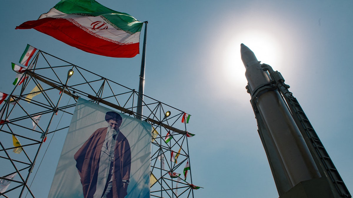 Iran ballistic missile stands next to image of Iran's leader Ayatollah Ali Khamenei.