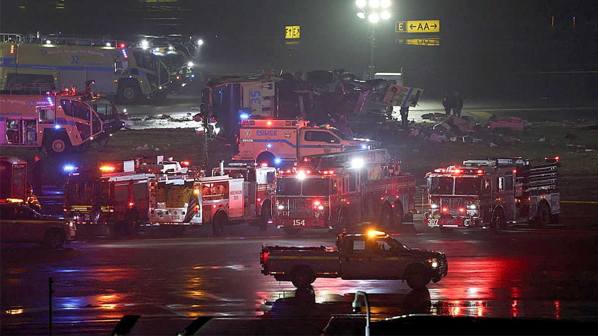 Emergency personnel respond to an Air Canada Express CRJ-900 after colliding with a Port Authority fire truck