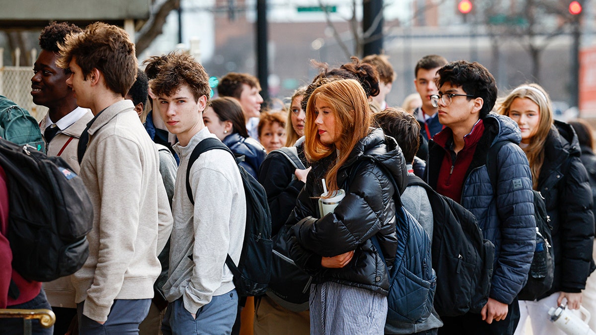 Mourners for Jimmy Gracey walk toward the entrance of the Church of the Holy Family in Chicago.