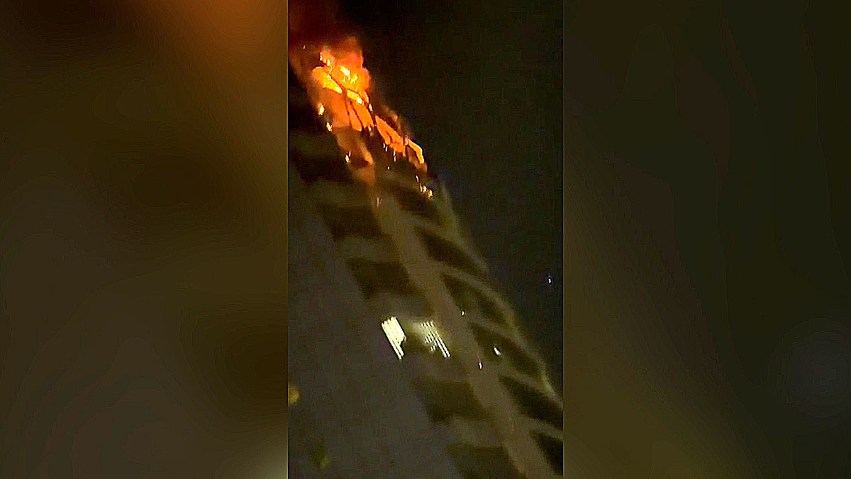 flames engulf several floors of a high-rise building