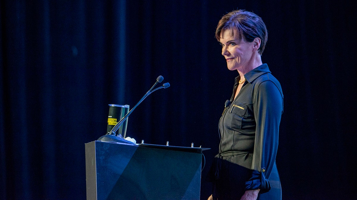 Candice DeLong at a podium speaking