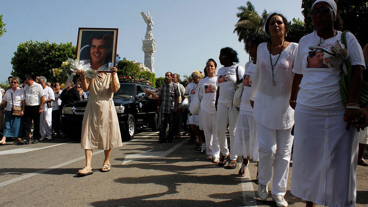 Opposition group march beside the funeral procession of Oswaldo Paya in Cuba
