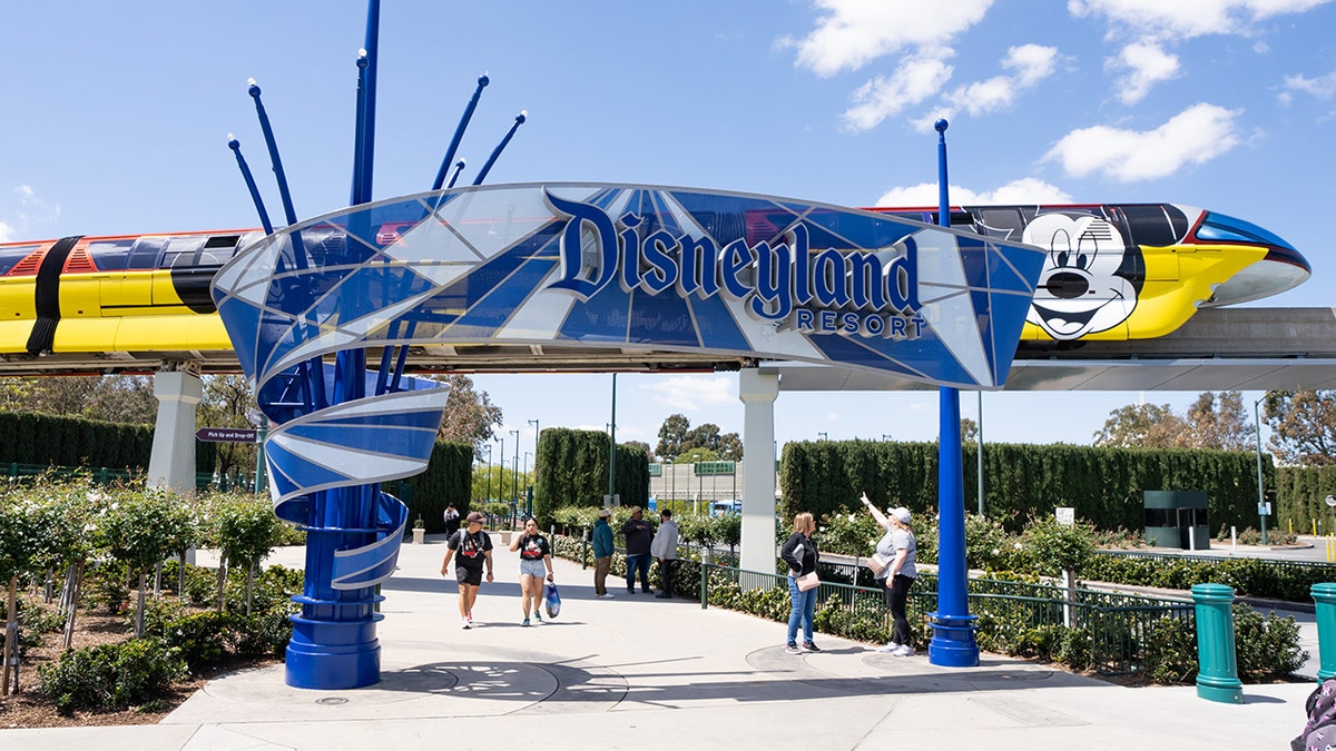 Disneyland Resort entrance sign with Monorail passing overhead in Anaheim, California.