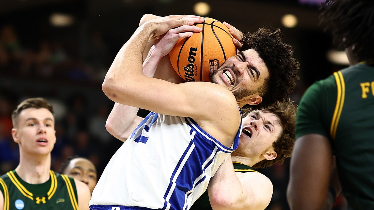 Cam Boozer and Riley Mulvey battle for basketball