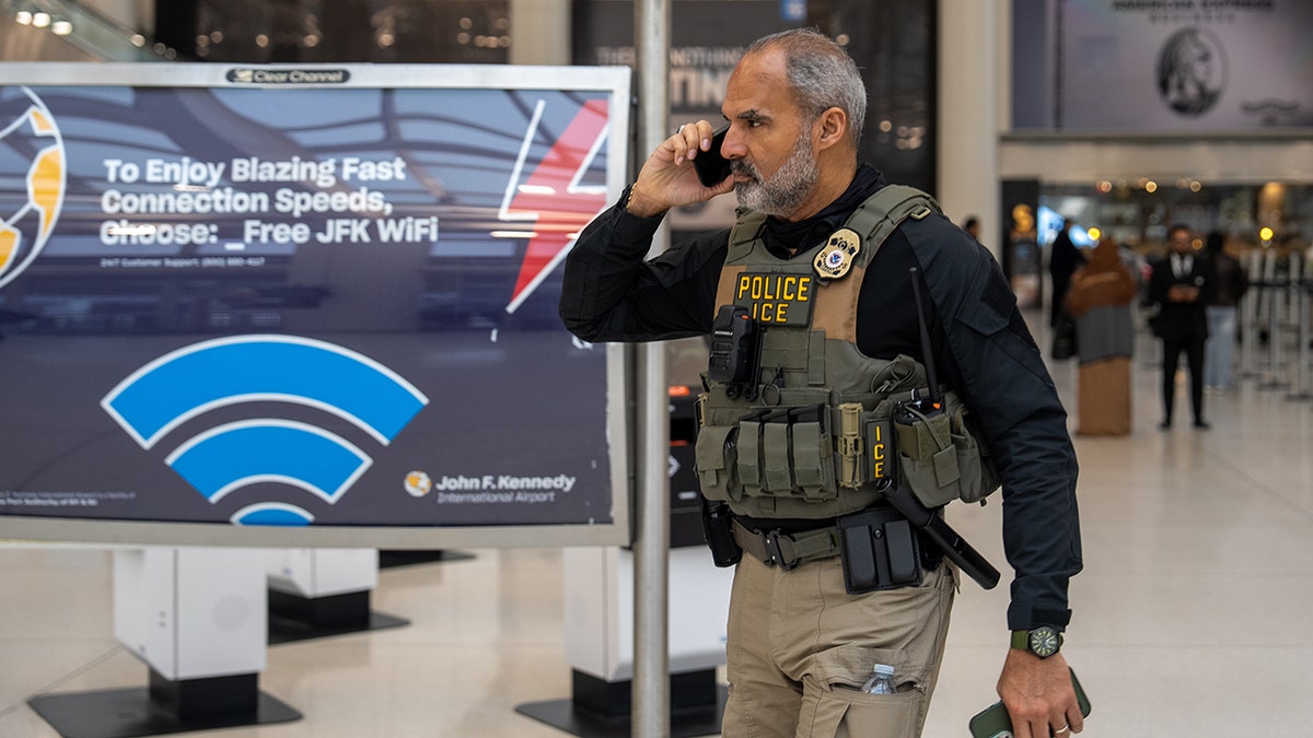 ICE agents walking through a terminal at JFK Airport.