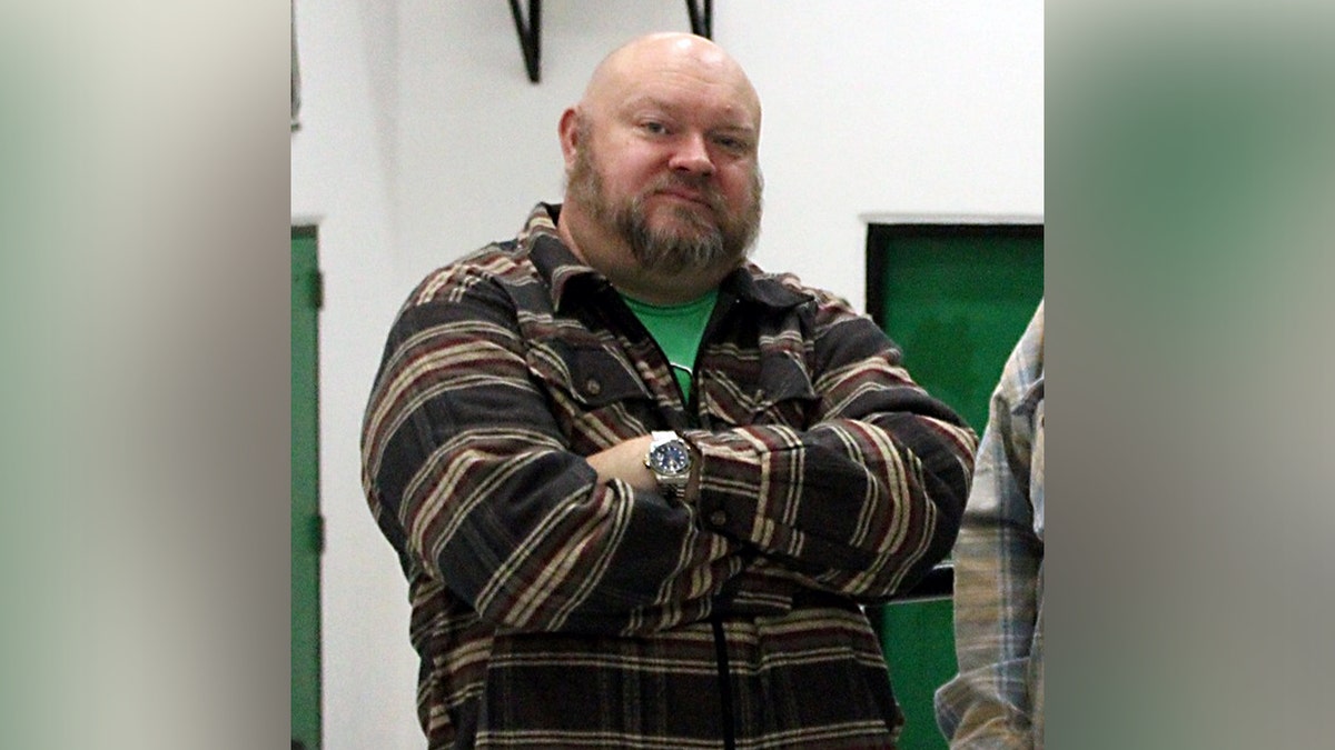 Former principal Jeremy P. Williams stands with arms crossed.