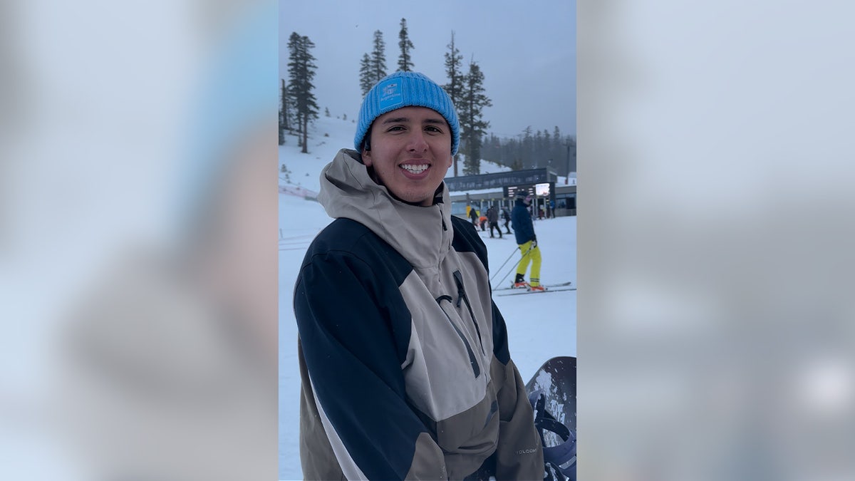 Julian Hernandez smiling, wearing a winter coat and hat