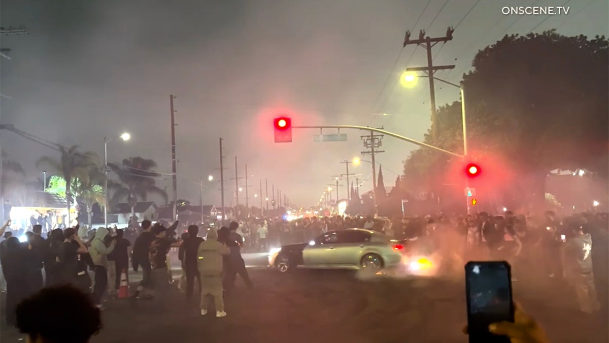 silver care doing donuts in intersection during street takeover