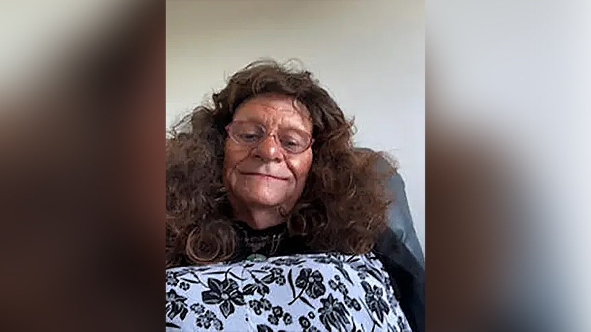 Reginald Arthurell wearing a long curly brown wig