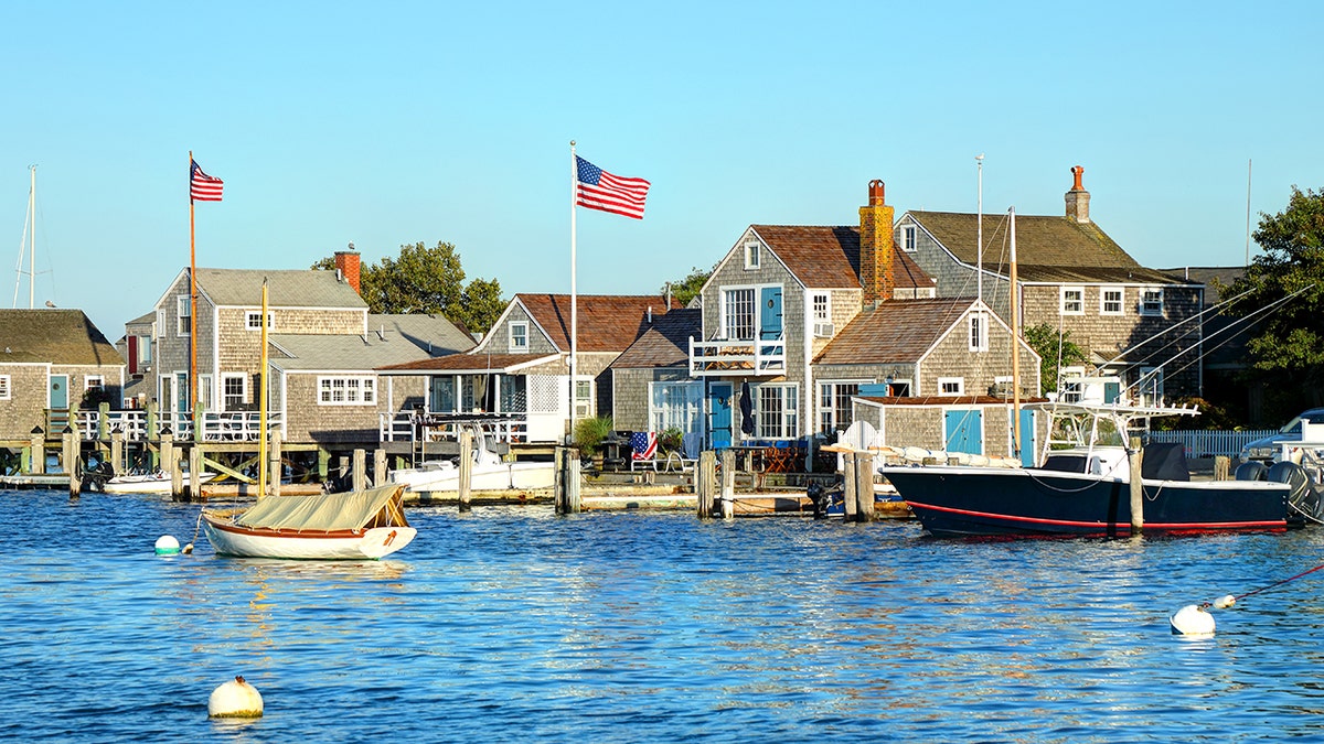 Nantucket waterfront homes with cedar shingle siding and American flags overlooking a harbor