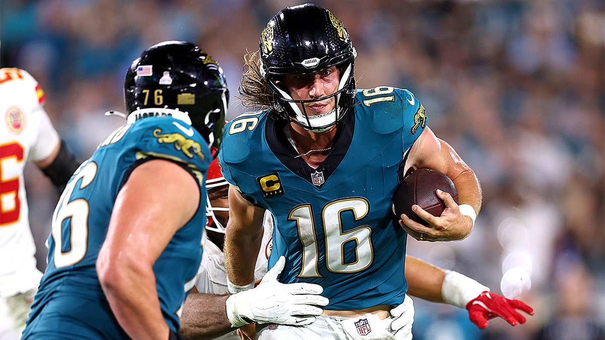 Trevor Lawrence diving toward the end zone while holding a football during a game at EverBank Stadium.