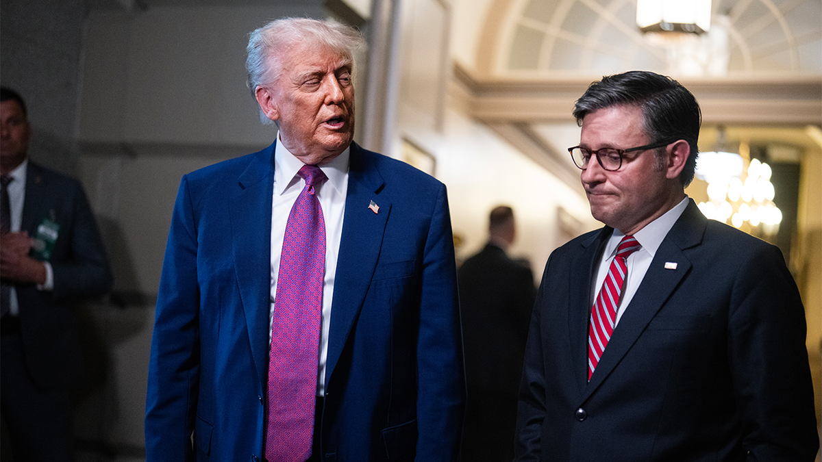 Donald Trump stands next to Mike Johnson