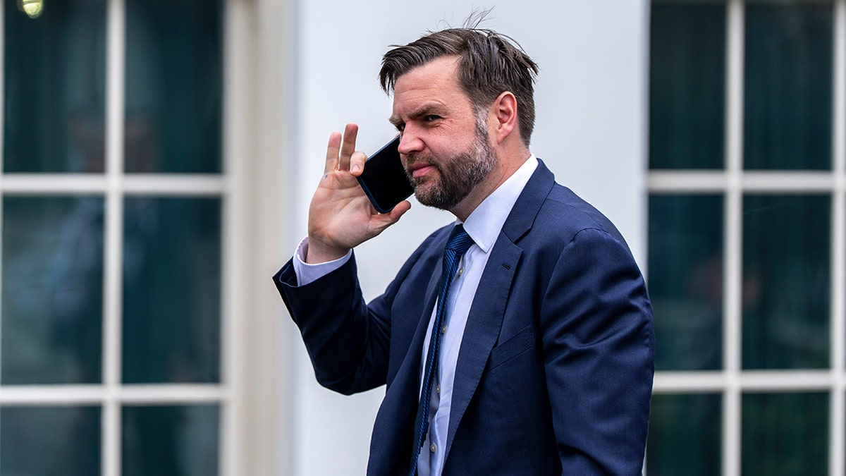 Vice President JD Vance talking on a cell phone while walking toward the West Wing.
