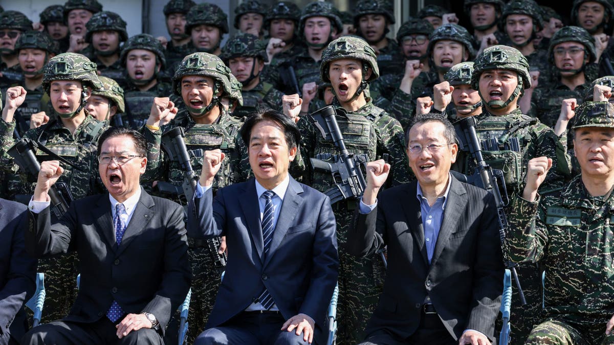 Taiwan's National Security Council Secretary-General Joseph Wu, Taiwan's President William Lai and Taiwan's Defense Minister Wellington Koo pose for photos with soldiers as they visit the troops.