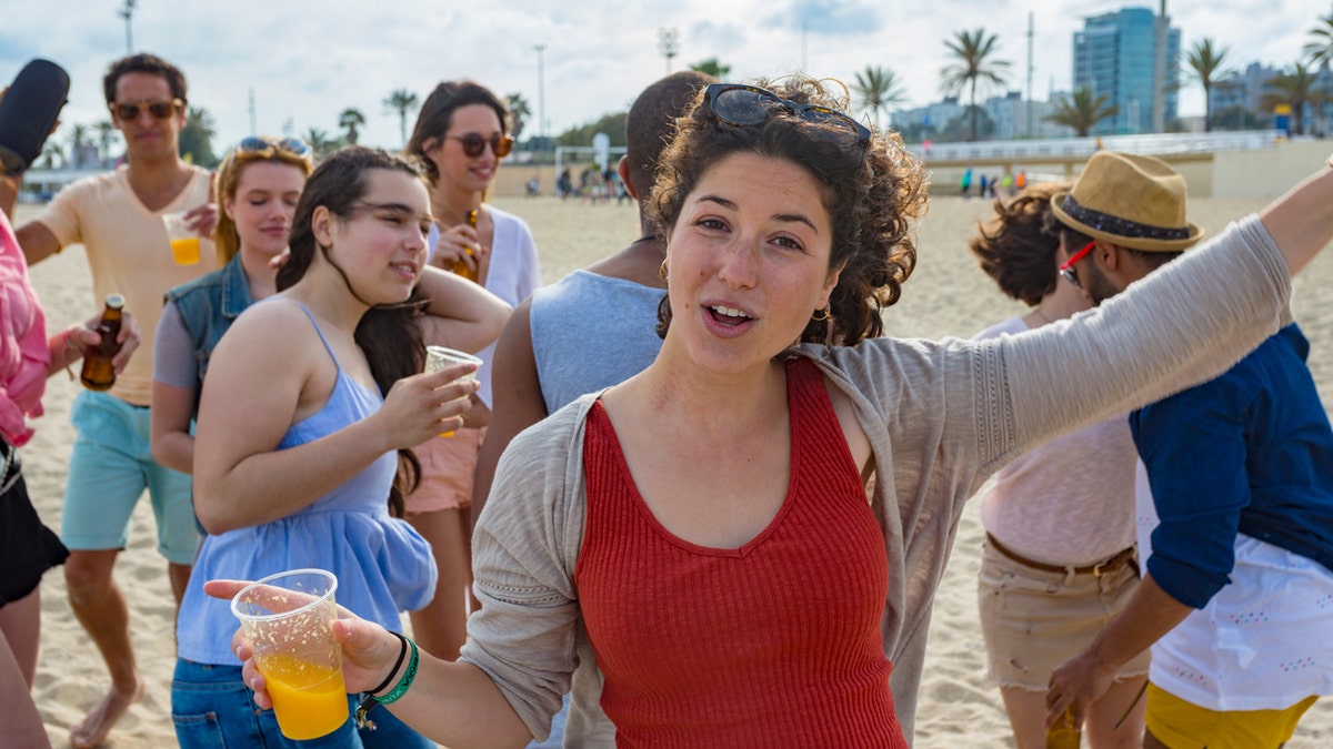 woman on beach drinking beer