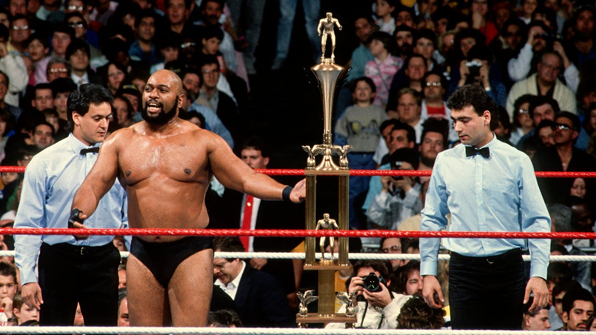 Bad News Brown holds a trophy