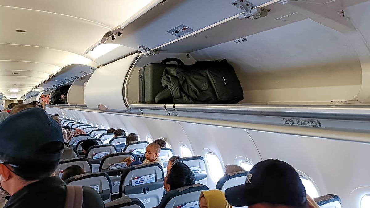 Carry-on baggage stored in overhead bin inside aircraft cabin