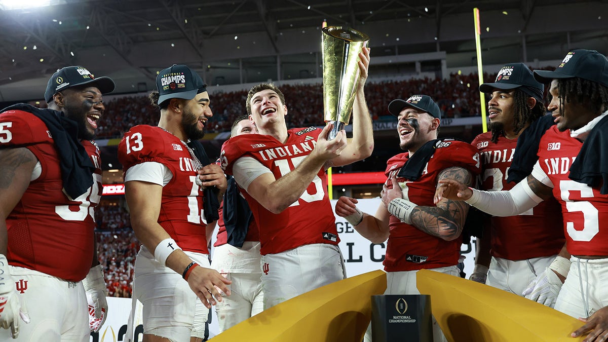 Indiana Hoosiers quarterback Fernando Mendoza holding up trophy at Hard Rock Stadium